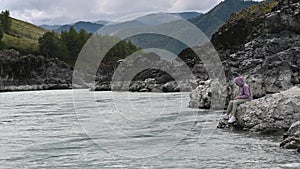 Woman on the bank of the mountain river Katun