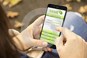 Woman with banking application phone in the park