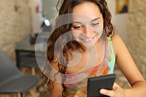 Woman in a bar using phone alone