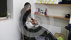 Woman barber washing man`s head