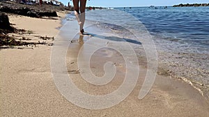 Woman barefeet walk along sand beach, Hot sunny weather, clear ocean water, Freedom life escape from city, summer