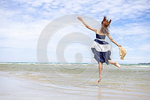 Woman barefoot jump in the water on summer along wave of sea water and sand on the beach