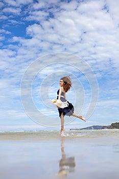 Woman barefoot jump in the water on summer along wave of sea water and sand on the beach