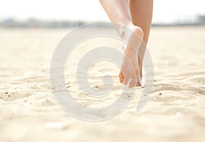 Woman barefoot walking on beach