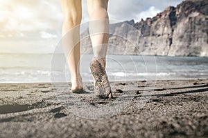 Woman barefoot walking on a beach, summer inspiration