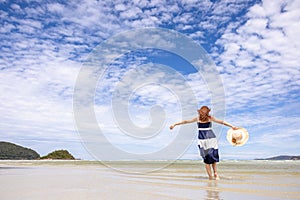 Woman barefoot walking on summer along wave of sea water and sand on the beach