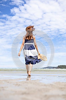 Woman barefoot walking on summer along wave of sea water and sand on the beach