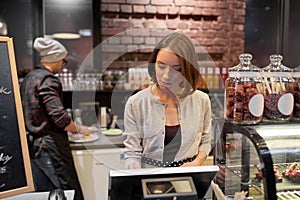 Woman or barmaid with cashbox at cafe