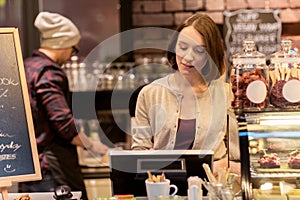 Woman bartender at cafe or coffee shop cashbox