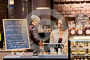 Woman bartender at cafe or coffee shop cashbox