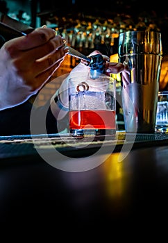 Woman bartender hand making cocktail in glass on bar