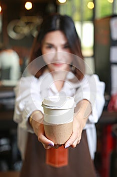 Woman bartender serving customer at coffee shop.