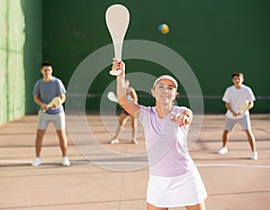 Woman Basque pelota player hitting ball with wooden racket photo