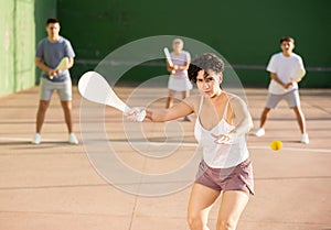 Woman Basque pelota player hitting ball with wooden racket photo