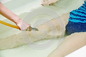 Woman in bath during hydromassage in beauty spa salon