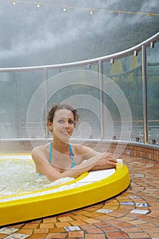 Woman bathes in open jacuzzi.