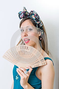 Woman in bathing suit holding a hand fan