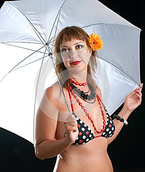 Woman in bathing suit with white umbrella