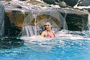 Woman bathing under a waterfall
