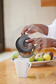 Woman in bathrobe pouring coffee