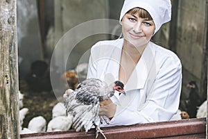 Woman in Bathrobe smiling young veterinarian checks the hens on