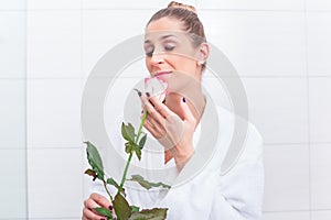 Woman in bathrobe with white rose