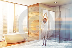 Woman in bathroom corner with tub and shower