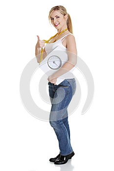 Woman with bathroom scale and measuring tape