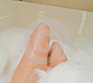 Woman in the bathtub with foam