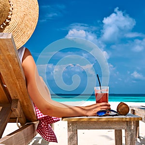 Woman at beach with chaise-lounges