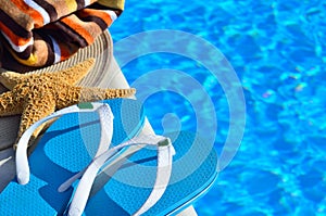 Woman beach hat, bright towel and blue flip-flops