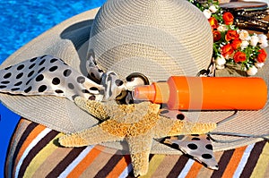Woman beach hat, bright towel, headphones.