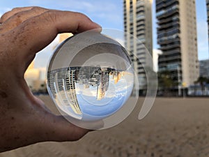 Woman on beach holding a crystal ball, beach resort. Creative concept, drea