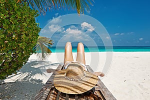 Woman at beach lying on chaise lounge