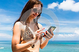 Woman on beach with phone chatting