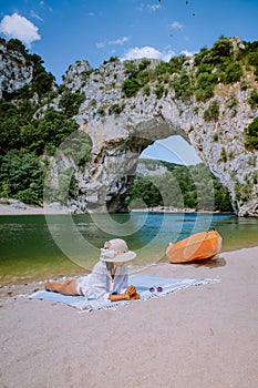 Woman on the beach by the river in the Ardeche France Pont d Arc, Ardeche France,view of Narural arch in Vallon Pont D