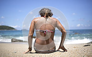 Woman on a beach with sand on her back