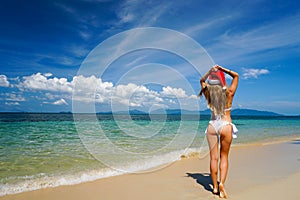 Woman on the Beach with Santa Claus Hat. Celebrating Christmas and New Year in Hot Country