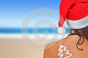 Woman on the beach in santas hat photo