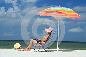 Una donna sul Spiaggia si siede sul sedie 