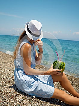 Woman on the beach with watermelon cocktail