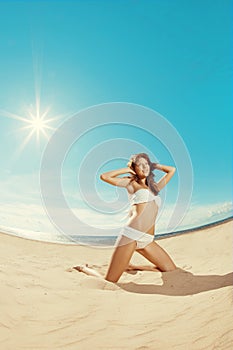 Woman on the beach. Young girl on the sand by sea.