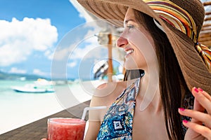 Woman in beachwear enjoying drink in beach cafe at sea