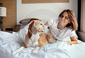 Woman and beagle dog wake up and meet new day in bed