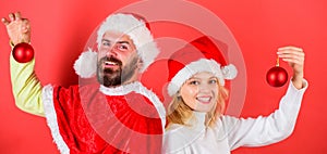 Woman and bearded man in santa hat stand back to back waiting christmas. Couple christmas santa costume hold ornament