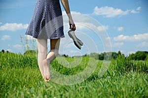 Woman bearfoot walk in grass