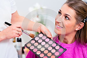 Woman with beautician in cosmetic salon