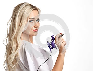 Woman beautician cosmetologist hold tattoo machine gun on white