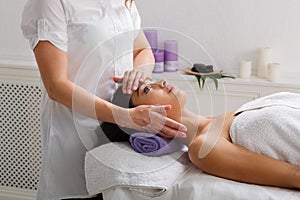 Woman beautician doctor make head massage in spa wellness center