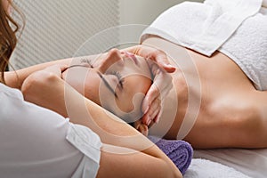 Woman beautician doctor make head massage in spa wellness center